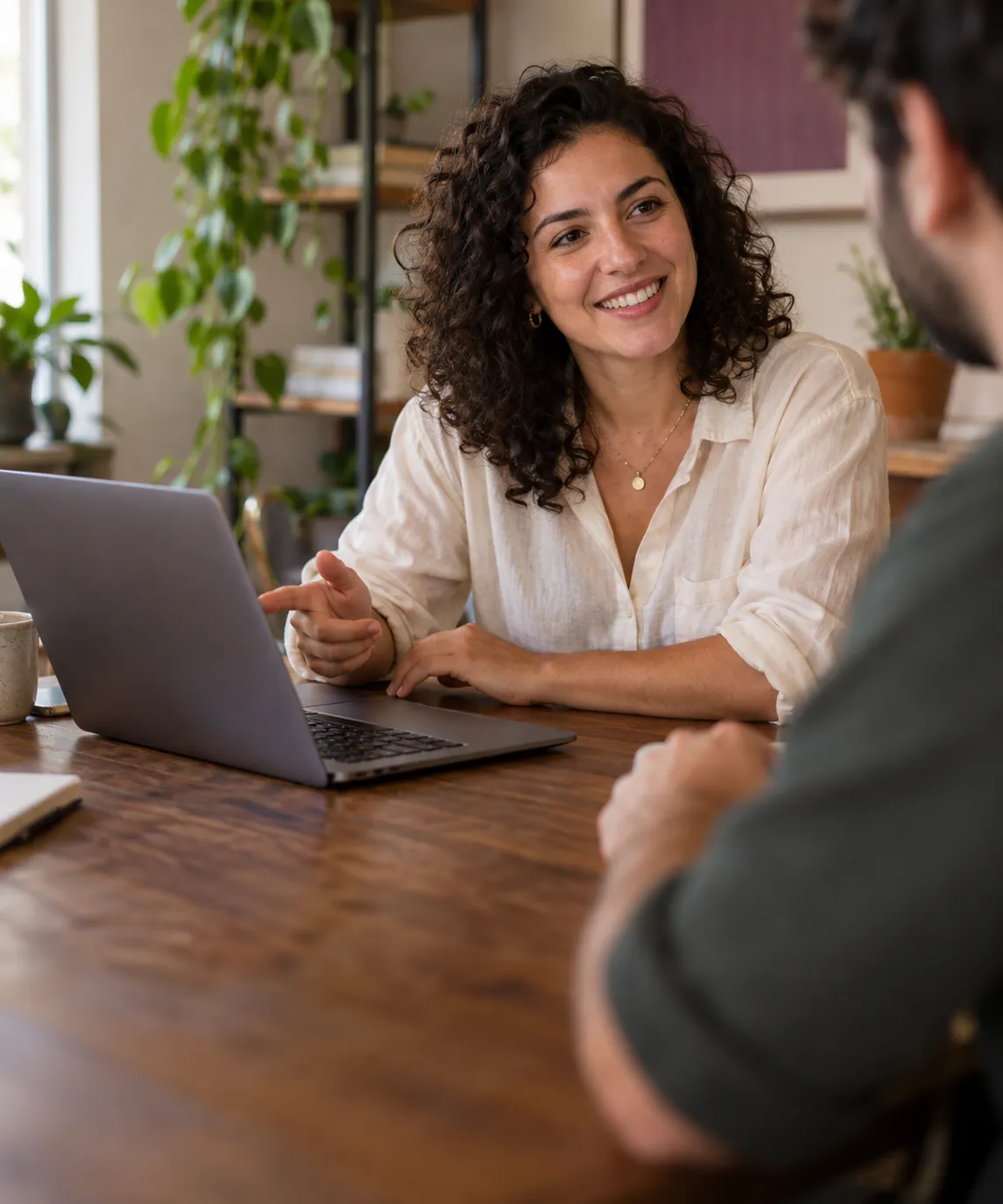 Cena ilustrativa de uma pessoa sorrindo durante uma conversa de trabalho com notebook.